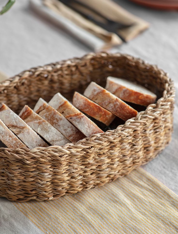 bread sticks in a woven basket on a table