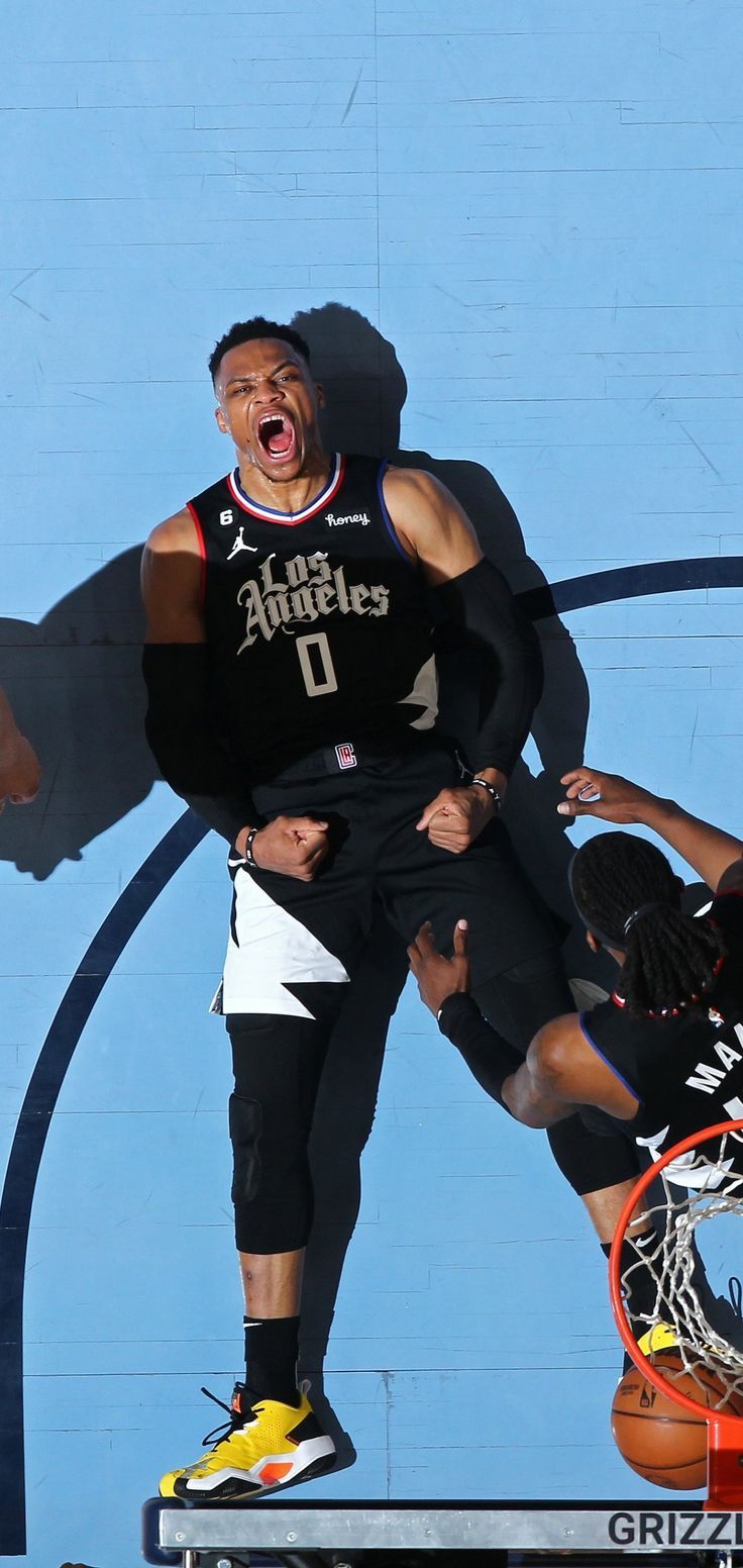 the basketball player is jumping up in the air with his arms out and mouth wide open