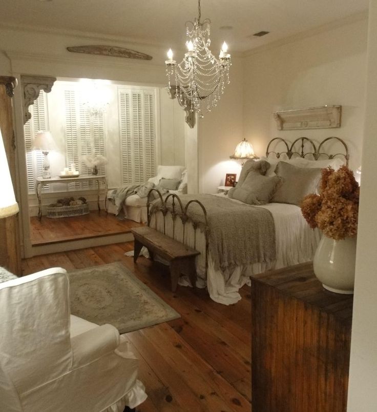 a bed room with a neatly made bed and a chandelier