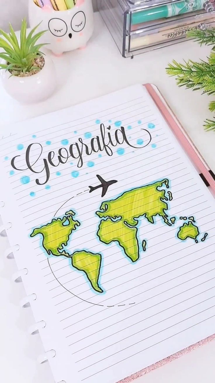 a notebook with the word geographia written on it next to some office supplies