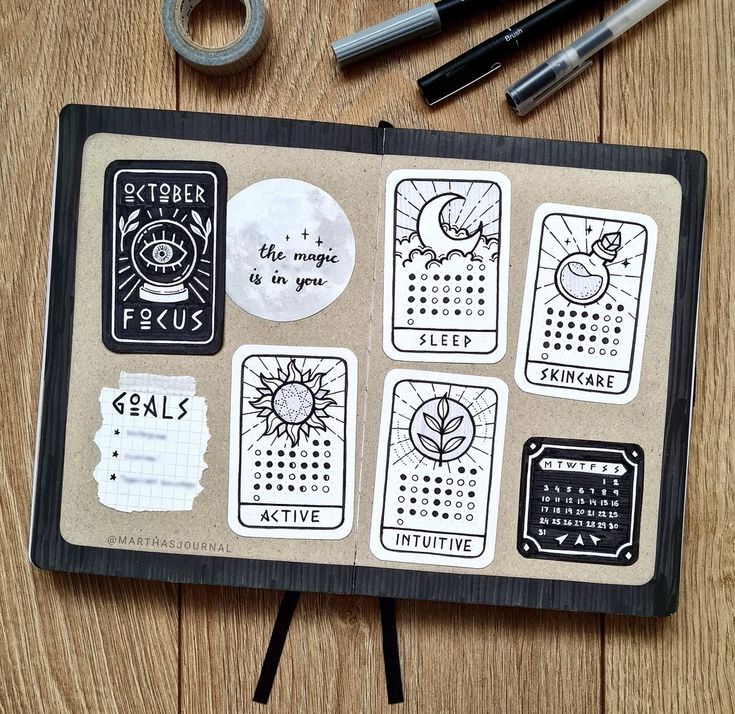 a wooden table topped with lots of stickers on top of a notebook covered in writing