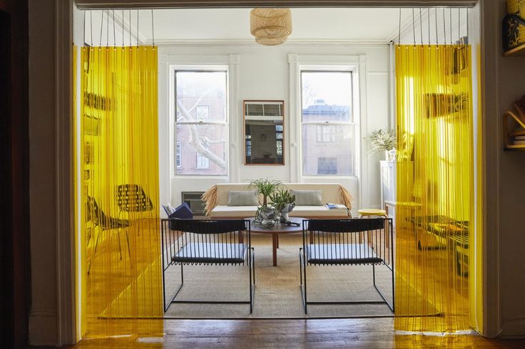 a living room filled with furniture and yellow curtains