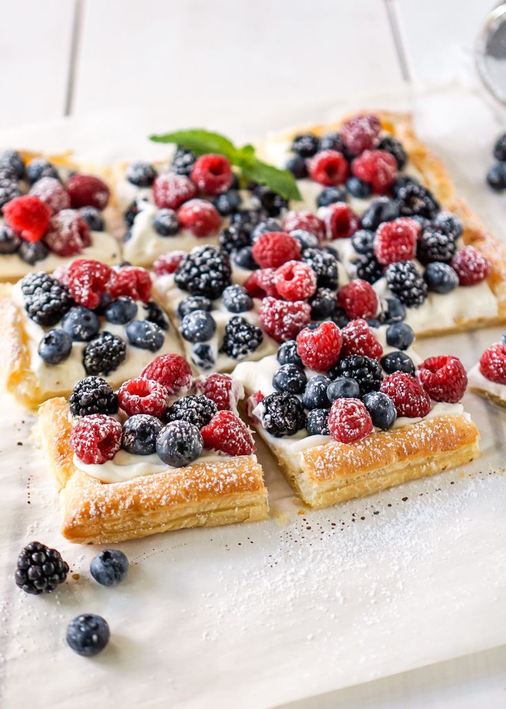 fruit pizza with cream cheese and fresh berries on top, ready to be cut into squares