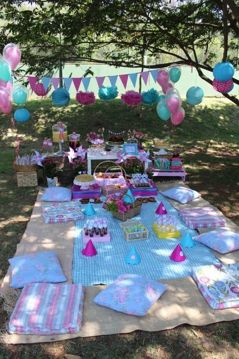 a picnic table set up with pink, blue and green decorations for a birthday party