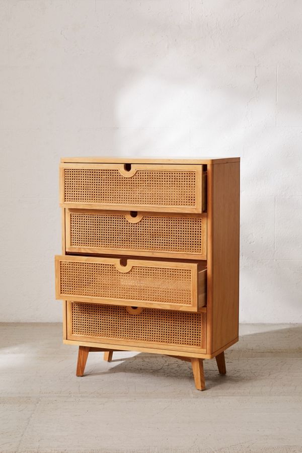 a wooden dresser with wicker drawers on the top and bottom, in front of a white wall