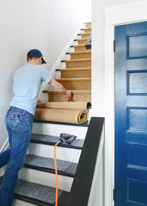 a man that is standing on some stairs with a hose in his hand and tape