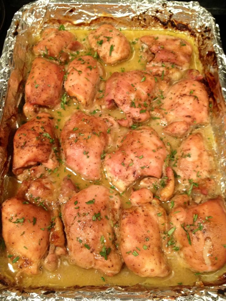 chicken and gravy in a baking dish on top of an oven sheet covered with tin foil