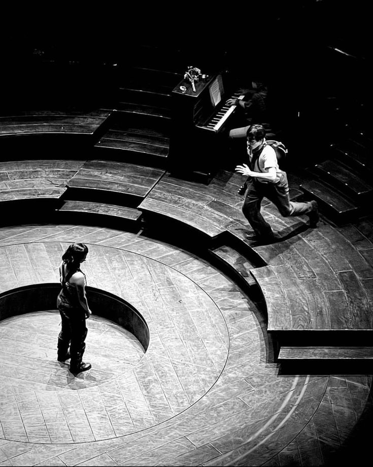 two people are standing in the middle of a circular stage