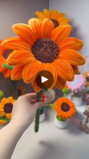 someone is holding a fake sunflower in their hand