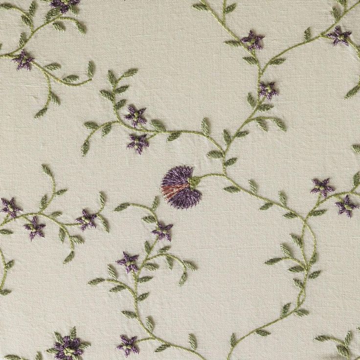 an embroidered fabric with purple flowers and green leaves