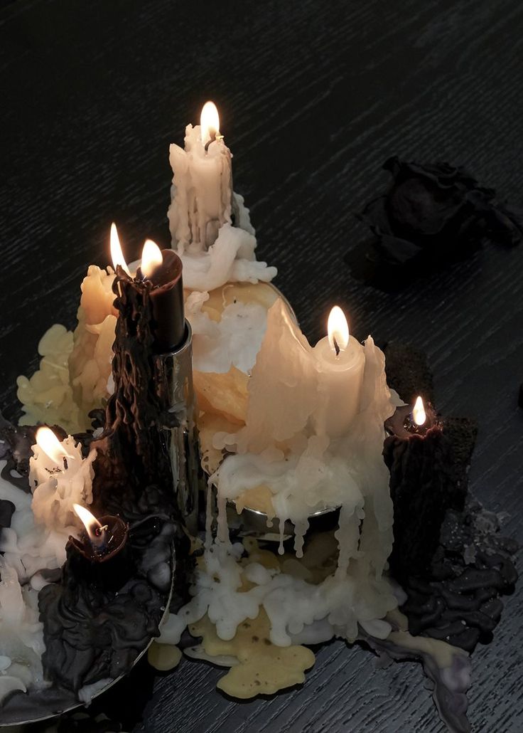 several lit candles sitting on top of a table next to other pieces of wood and paper