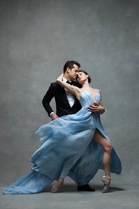 a man and woman dance together in an artistic pose with their arms around each other