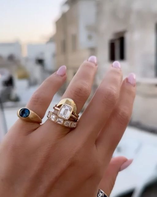 a woman's hand with two rings on top of it and one ring in the middle