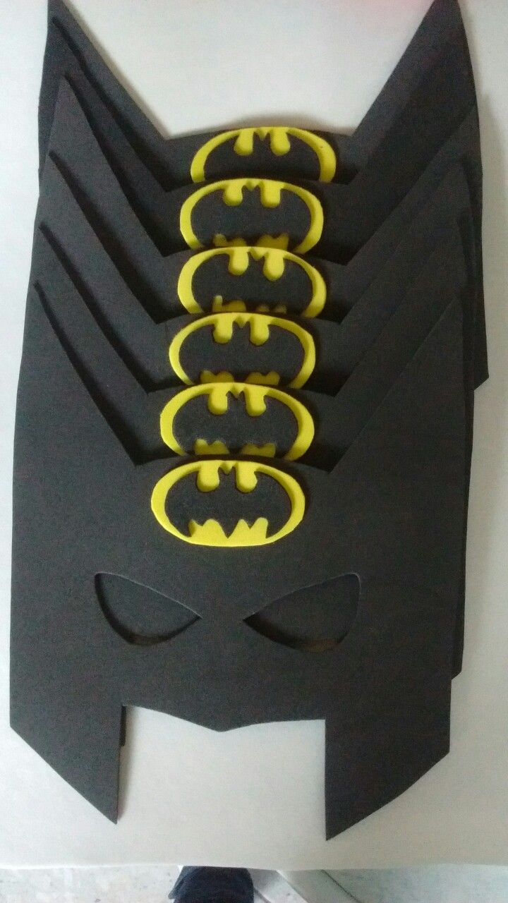 a batman mask made out of black paper with yellow buttons on the front and back