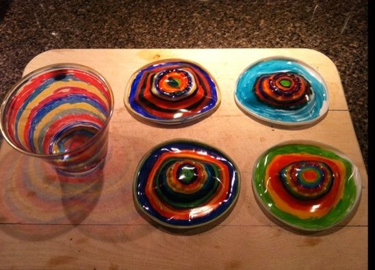 six colorful glass plates sitting on top of a wooden tray