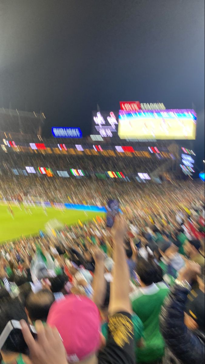 a crowd of people at a baseball game with their cell phones up in the air