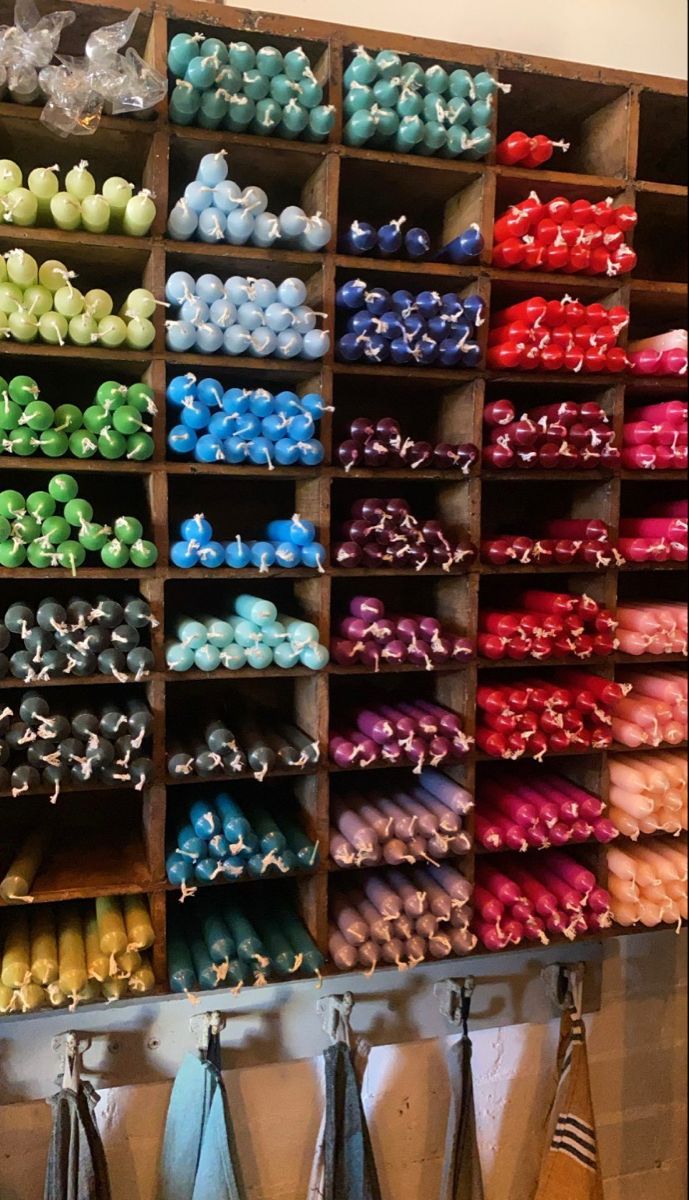 several rows of different colored shoes and ties on display in a room with wooden shelves