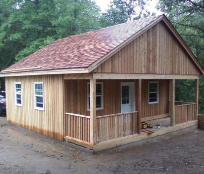 a small wooden house with a porch and covered porch