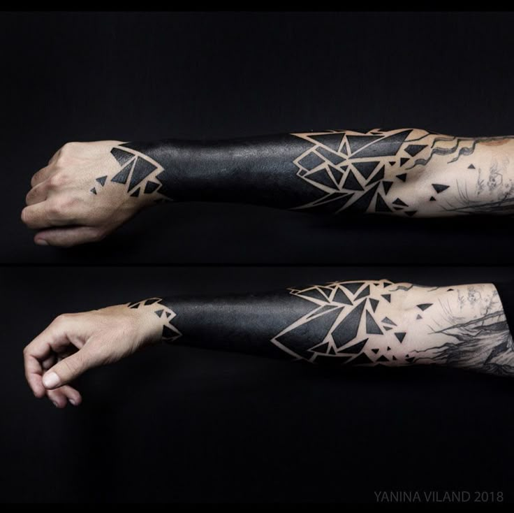 the arm is covered in black ink and has an intricate design on it, as well as