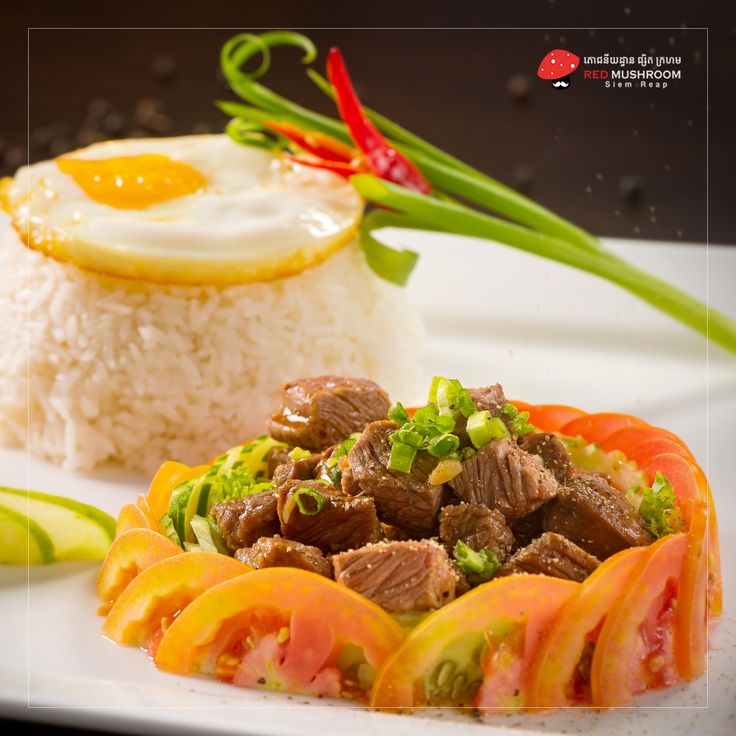 a white plate topped with rice, meat and veggies