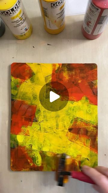 someone is painting on a piece of wood with acrylic paint and some glue