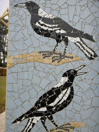 two black and white birds sitting on top of a mosaic