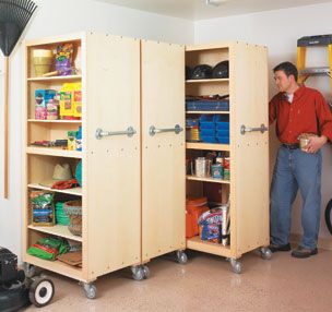 a man standing next to a large wooden cabinet in a room with tools and other items