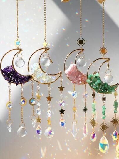 the moon and stars mobile is hanging from chains with crystal beads, swaroes, and crystals