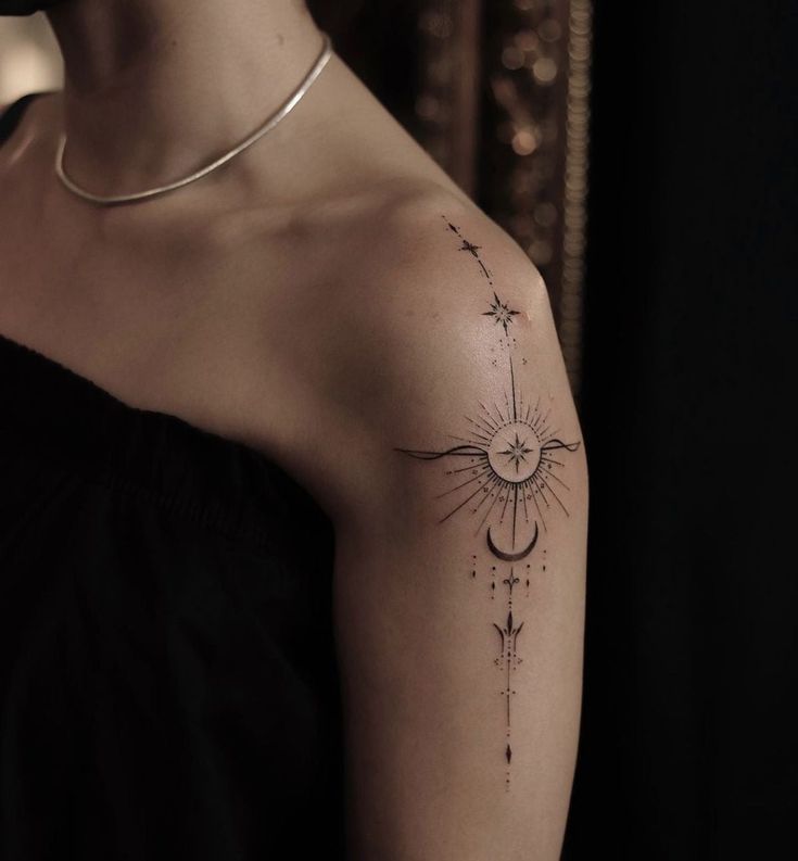 a woman's arm with a tattoo on it that has an arrow and stars