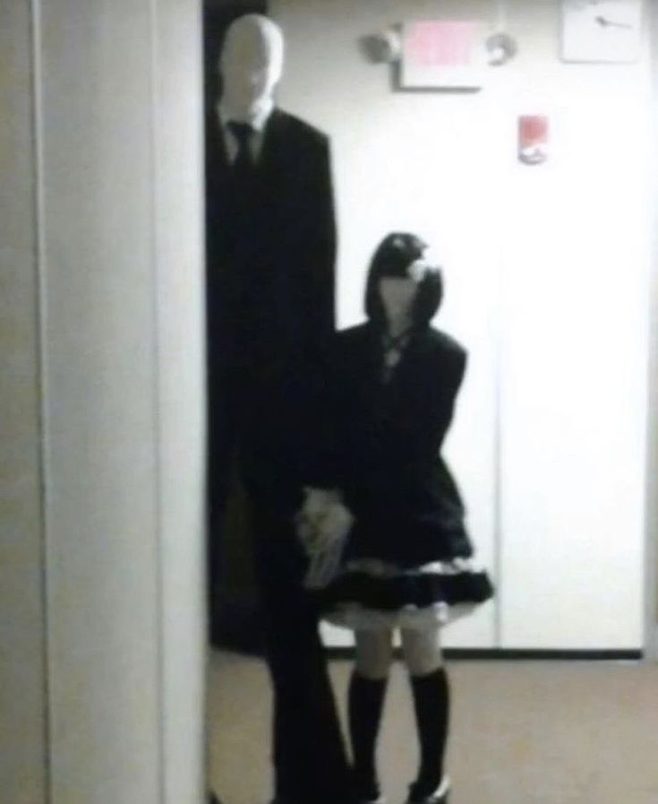 a man in a suit and tie standing next to a mannequin wearing a skirt