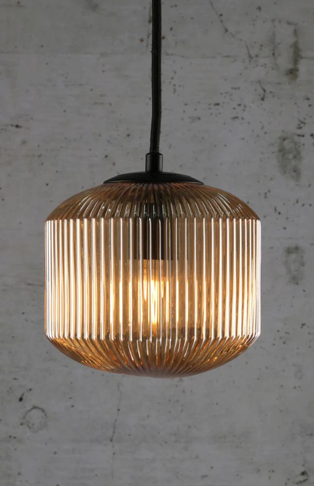 a light that is hanging from the ceiling in front of a concrete wall and floor