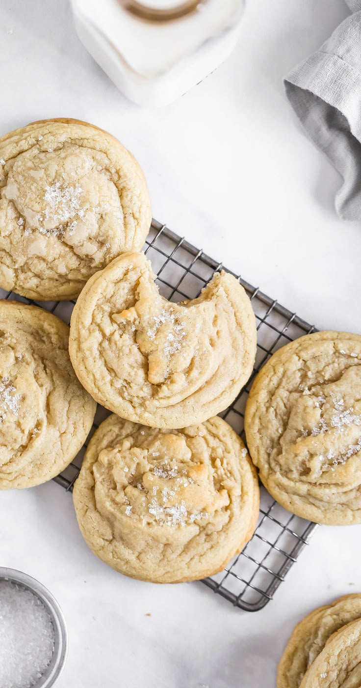 several cookies cooling on a wire rack with powdered sugar in the middle and one cookie sitting next to it