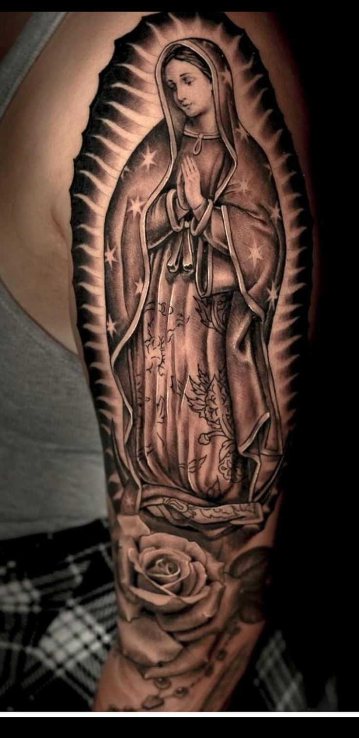 a woman's arm with a black and white image of the virgin mary on it