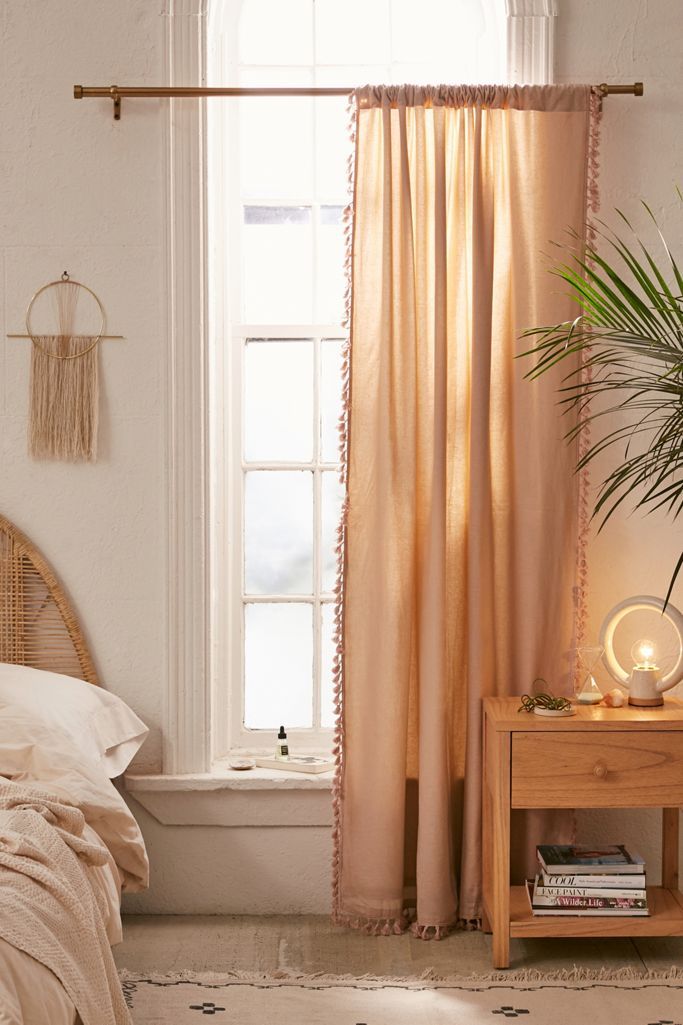 a bedroom with a bed, window and plant on the side table in front of it