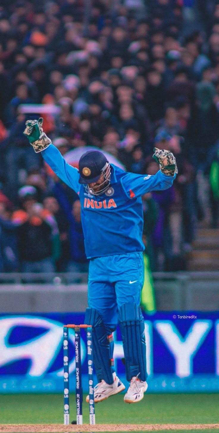 a man in blue uniform playing a game of cricket