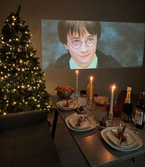 a christmas tree is in front of a projection screen with harry potter glasses on it