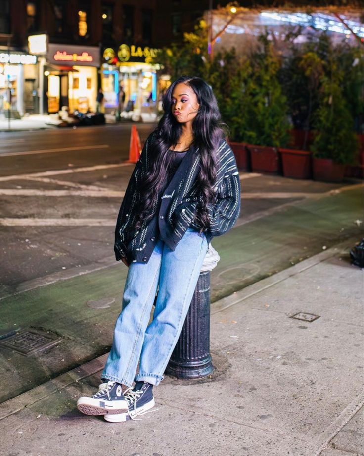 a woman standing on the sidewalk next to a fire hydrant