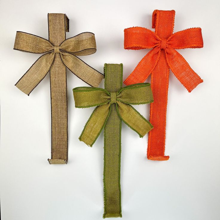 three different colored ribbons tied together on a white surface with an orange and green bow