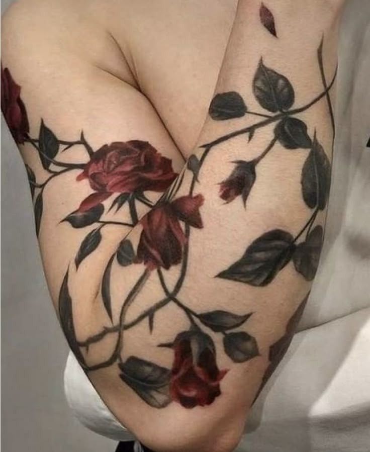 a woman's arm with flowers on it and leaves all over the arm,