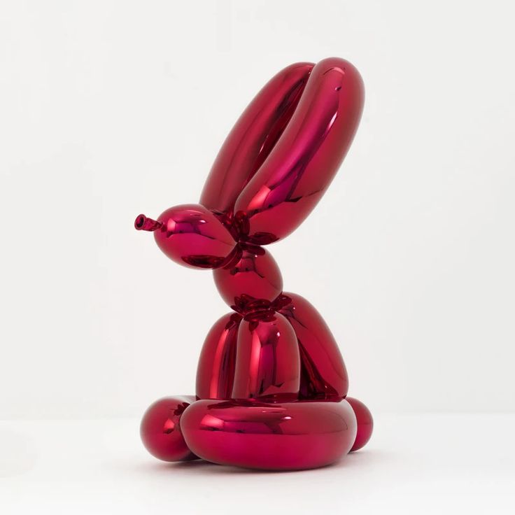 a red balloon dog sitting on top of a white table