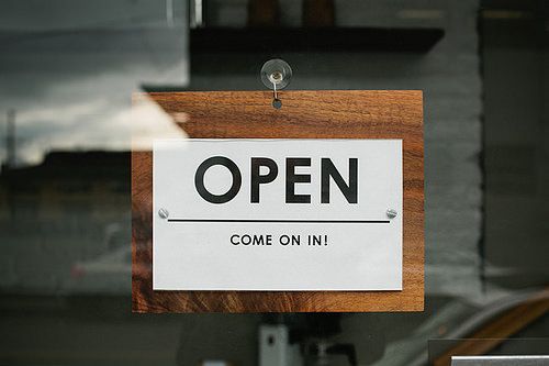 an open sign is hanging on the glass door