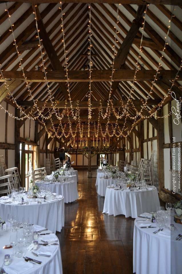 tables are set up in the middle of a room with lights strung from the ceiling