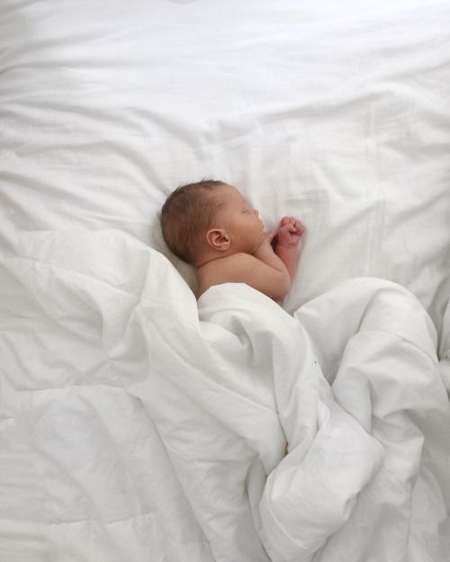 a baby is sleeping in a white blanket