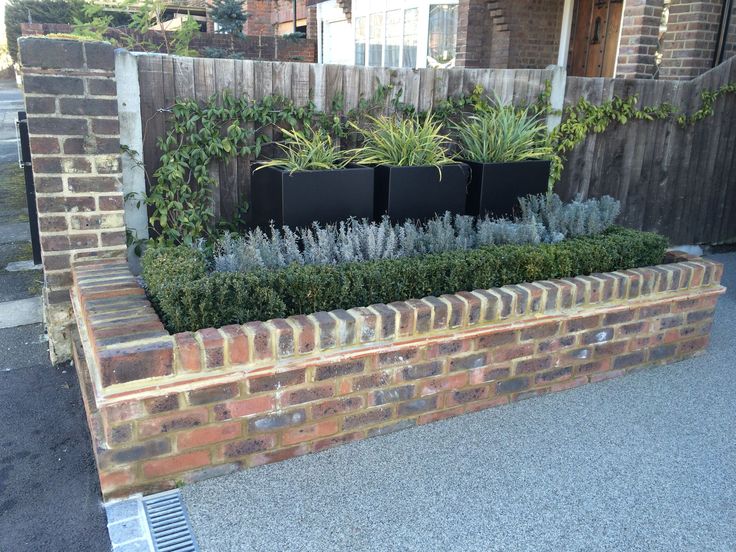 a brick planter filled with lots of plants