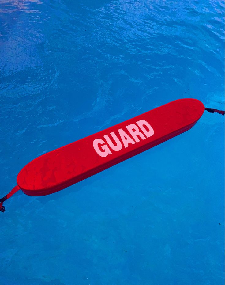 a red surfboard floating in the water