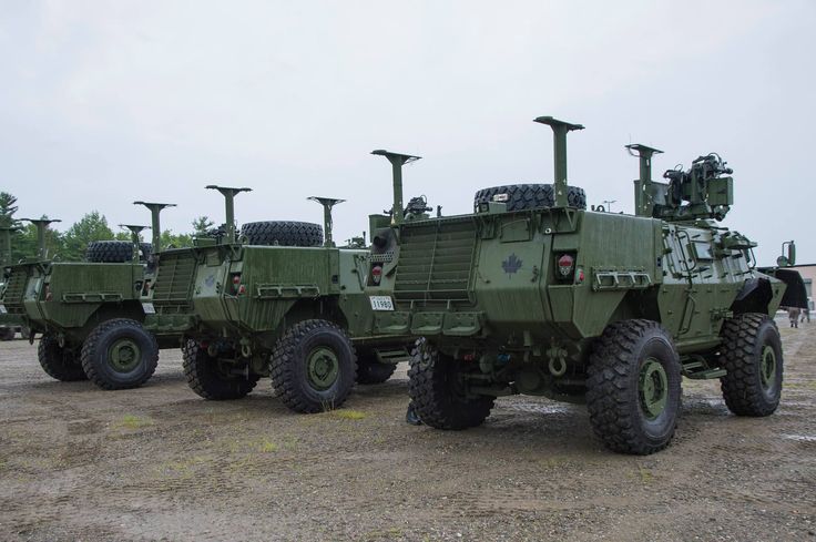 several army vehicles parked in a parking lot