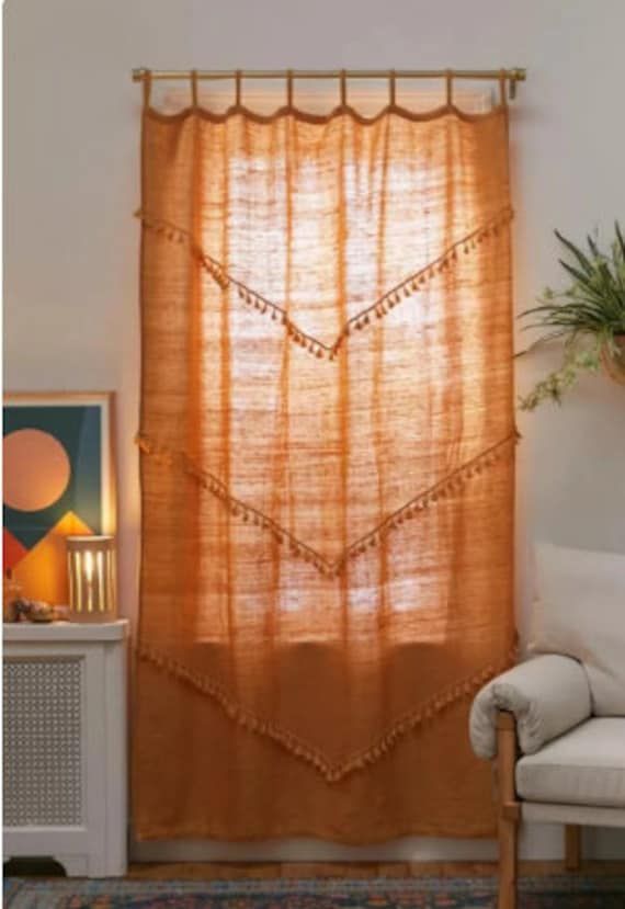 a living room with a white couch and orange curtains