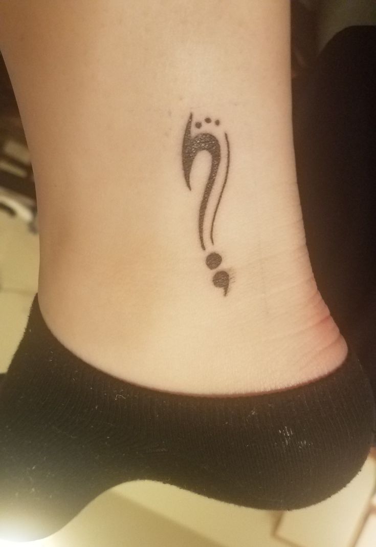 a small tattoo on the ankle of a woman's foot with a question mark