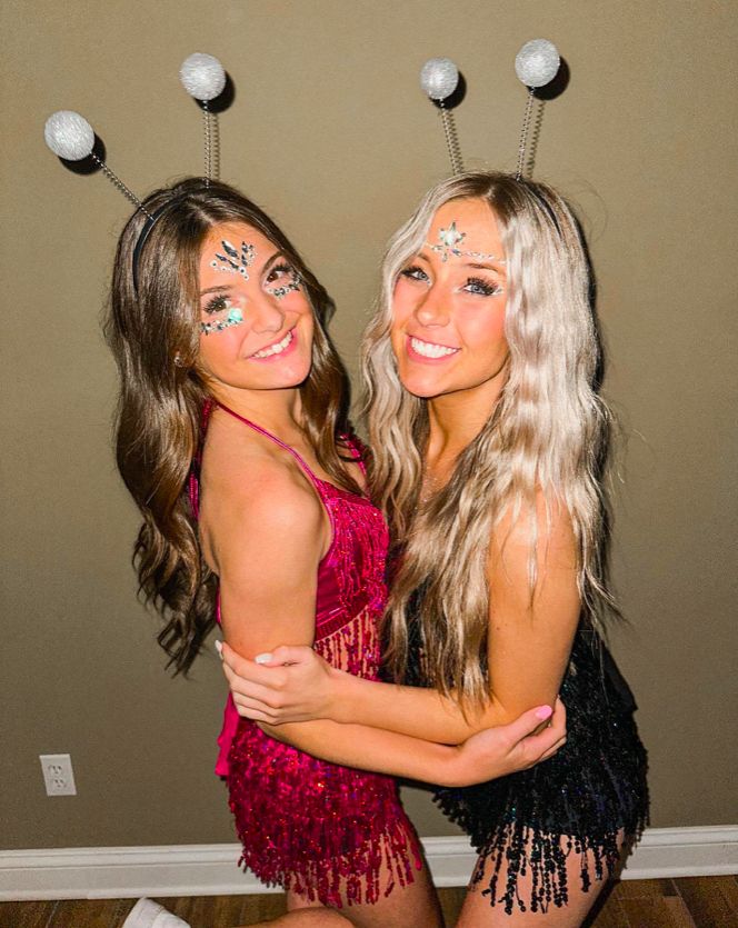 two young women dressed in costumes posing for the camera with their arms around each other