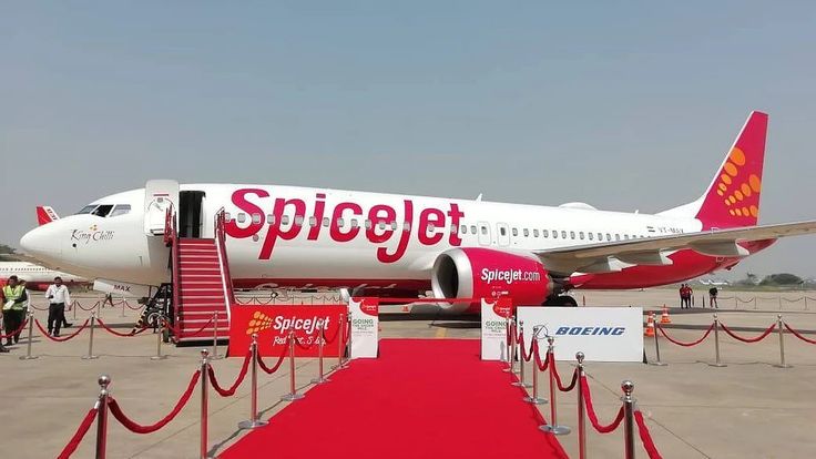 a large jetliner sitting on top of an airport tarmac next to a red carpet